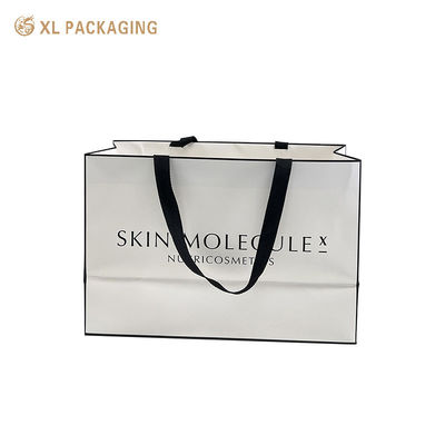Sac cadeau en papier d'art blanc mat de luxe de marque personnalisé avec poignée de ruban tissé noir large pour la vente au détail de cosmétiques