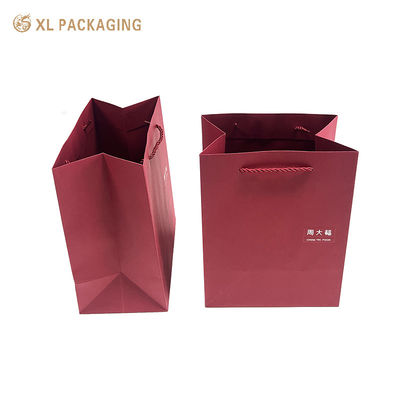 Sac cadeau en papier rouge de luxe avec logo personnalisé, fond plié renforcé et poignées en papier tordu pour les achats haut de gamme et l'emballage de cadeaux