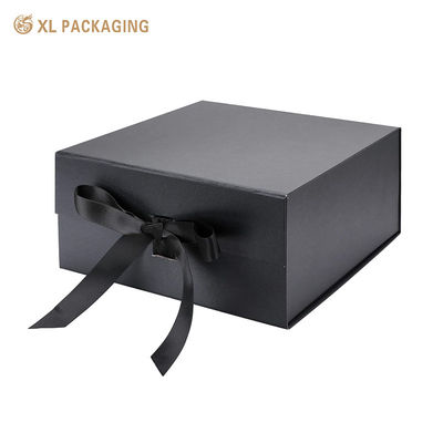 Une boîte cadeau magnétique noire avec fermeture à ruban.